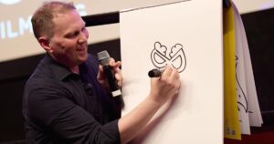 person with a microphone drawing on paper with a marker